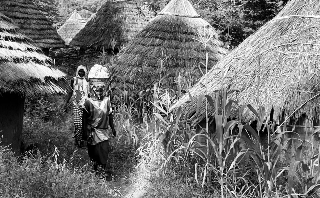 Mujeres caminando entre las chozas de Iwol